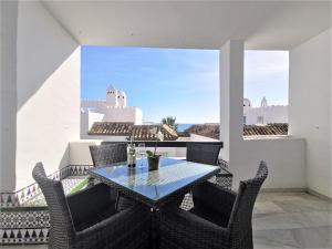 una mesa y sillas en un balcón con vistas al océano en Playa Lucera - ground floor apartment with sea views CS126, en Sitio de Calahonda