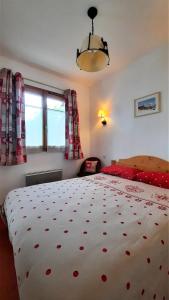 a bedroom with a large white bed with red sheets at Appt T2 Cabine 4-6 personnes au pied des pistes in Orcières +21 photos