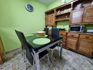een keuken met een tafel met stoelen en een magnetron bij 126B Apto Playa - 3 Habitaciones in Gijón