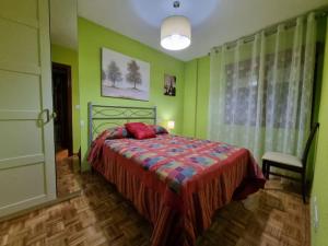 een slaapkamer met een bed met groene muren bij 126B Apto Playa - 3 Habitaciones in Gijón