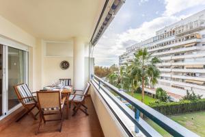 a balcony with a table and chairs and a view of a building at Beautiful Apartment with Pool in Marbella