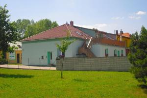 a white house with a staircase and a brick wall at Penzion u Balcarky in Ostrov u Macochy