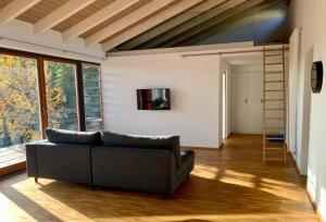 ein Wohnzimmer mit einem Sofa und einem TV an der Wand in der Unterkunft Ferienloft Talblick Detmold Berlebeck in Detmold