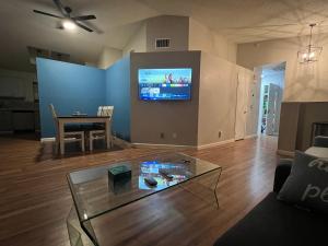 a living room with a table and a tv on a wall at Large Pool & Patio Cozy Single Story Family House in Las Vegas