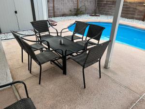 a black table and chairs next to a pool at Large Pool & Patio Cozy Single Story Family House in Las Vegas