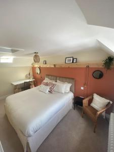 a bedroom with a large white bed and a chair at Wee Cottage - Super King bed! in Penpont