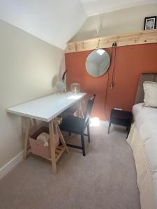 Zimmer mit einem Schreibtisch und einem Bett sowie einem Tisch und Stühlen in der Unterkunft Wee Cottage - Super King bed! in Penpont