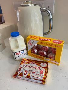 a counter top with a jug of milk and a box of cookies at Wee Cottage - Super King bed! in Penpont