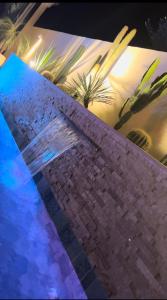 una pared de piedra junto a una piscina por la noche en Villa Nawel Piscine privée et chauffée sans vis-à-vis, en Agadir