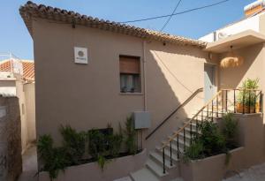 ein Haus mit einer Treppe, die zu einem Fenster führt in der Unterkunft Pylosea Luxury Lodge in Pylos