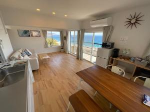 uma sala de estar com vista para o oceano em Sirahama Beach House em Shimoda