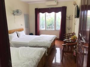 a hotel room with two beds and a window at KHÁCH SẠN HÀ ANH 1 NỘI BÀI in Noi Bai