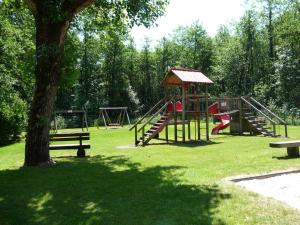a park with several playground equipment in the grass at Ferienwohnung Eichenseher in Bodensdorf
