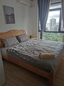 1 cama en un dormitorio con ventana grande en 森林城市豪华公寓房, en Kampong Pekajang Bengkok