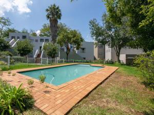 a swimming pool in a yard with a wooden deck at RAD STAYS - 26 Madison Palms East 112 North Road Sandown in Johannesburg