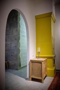a room with a yellow wall and a table with candles at Kotun Gyumri in Gyumri