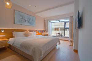a bedroom with a large bed and a window at Sky Palace Hotel in Guilin
