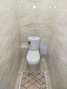 ein Bad mit einem weißen WC in einem Zimmer in der Unterkunft Отличная 3х комнатная квартира in Oral