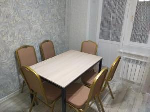 einen Tisch und 4 Stühle in einem Zimmer in der Unterkunft Отличная 3х комнатная квартира in Oral