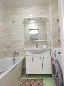 ein Badezimmer mit einem Waschbecken und einer Waschmaschine in der Unterkunft Отличная 3х комнатная квартира in Oral