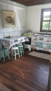 a kitchen with a counter and a table and chairs at Quartos Casa da Ilha do Mel - Nova Brasília in Ilha do Mel