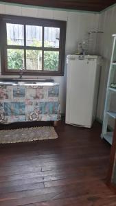 uma cozinha com um frigorífico, um lavatório e uma janela em Quartos Casa da Ilha do Mel - Nova Brasília na Ilha do Mel