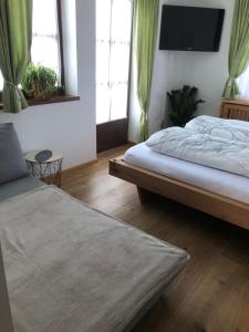 a bedroom with two beds and a flat screen tv at Luserblick in Haus im Ennstal