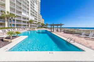 a swimming pool in front of a building and the ocean at White Caps 204 in Orange Beach
