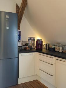 a kitchen with white cabinets and a blue refrigerator at Luxuriöses Penthouse mit Dachterrasse & Massagesessel EM-APARTMENTS DEUTSCHLAND in Bielefeld