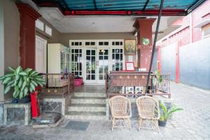 - une terrasse couverte avec des chaises et une porte dans l'établissement RedDoorz at Oro Oro Ombo Batu, à Tlekung