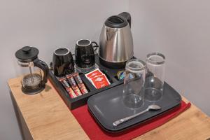 a tray with a tea kettle and glasses on a table at Exarchia House Project in Athens