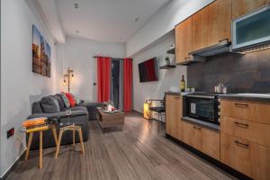 a living room with a gray couch and a kitchen at Exarchia House Project in Athens