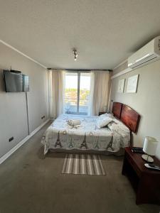 a bedroom with a bed and a large window at Departamento Buena vista in Talca