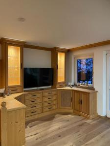 uma ampla sala de estar com uma televisão de ecrã plano em Haus Almweg em Kirchberg in Tirol
