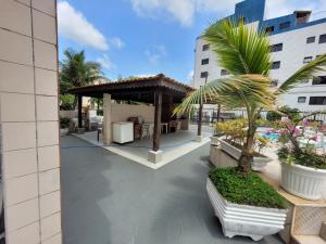 eine Terrasse mit einem Pavillon und einer Palme in der Unterkunft Ótimo apto Enseada Guarujá in Guarujá
