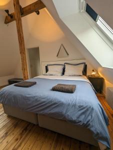 ein Schlafzimmer mit einem großen Bett im Dachgeschoss in der Unterkunft Luxuriöses Penthouse mit Dachterrasse & Massagesessel EM-APARTMENTS DEUTSCHLAND in Bielefeld