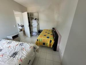 ein Schlafzimmer mit zwei Betten und einem Spiegel in der Unterkunft Ótimo apto Enseada Guarujá in Guarujá + 10 Fotos