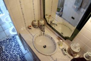 a bathroom with a sink and a tub with a mirror at B&B Villa Moro - Family House in Domodossola