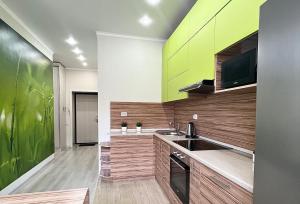 una cocina con armarios verdes y marrones y fregadero en Апартаменты в новом ЖК, en Pavlodar