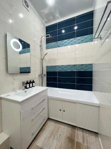 a white bathroom with a tub and a sink at Апартаменты в новом ЖК in Pavlodar