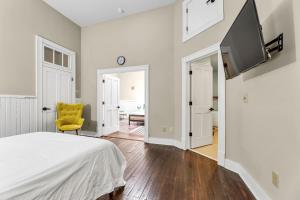 1 dormitorio con 1 cama y 1 silla amarilla en Elm St Retro Retreat- Downtown Close to Local Amenities en Greensboro