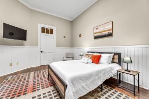 a bedroom with a large bed and a flat screen tv at Elm St Retro Retreat- Downtown Close to Local Amenities in Greensboro