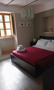a bedroom with a large bed with a red blanket at Al Noceto Countryside in Busso