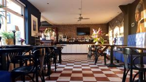 een restaurant met tafels en stoelen en een geruite vloer bij Logement Hellevoetsluis in Hellevoetsluis