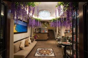 a lobby with purple flowers hanging from the ceiling at West Loch Park Hotel Vigan in Vigan