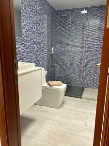 Un baño con inodoro, lavabo y ducha. en Villa Pousadoiro, en Playa Blanca