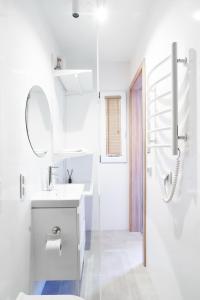a white bathroom with a sink and a mirror at Wyspa Wisła Przyjazna Przystań Stężyca in Stężyca