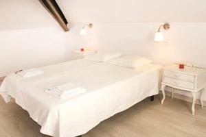 - une chambre blanche avec un lit blanc et une table de chevet dans l'établissement Precioso estudio, à Arenas de San Pedro