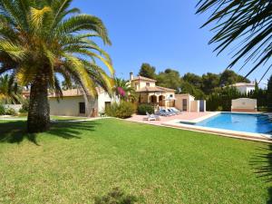 a house with a palm tree and a swimming pool at Casa Delfin in Jávea