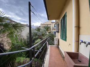 a balcony of a building with a staircase and palm trees at Accademia Apartment in Florence